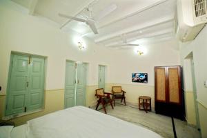 a bedroom with a bed and a table and chairs at Shree Krishna Bhakti Ashram in Vrindāvan