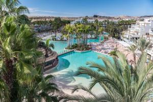 an aerial view of a resort swimming pool with palm trees at Tabaiba Princess in Maspalomas