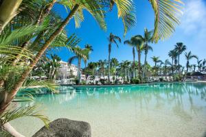 a swimming pool with palm trees in the foreground at Tabaiba Princess in Maspalomas +114 photos