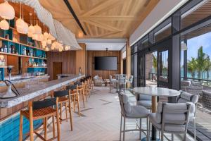 a restaurant with a bar and tables and chairs at Hilton Tulum Riviera Maya All-Inclusive Resort in Tulum