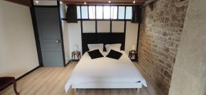a bedroom with a white bed with pillows on it at Gîte Le Petit Menhir in Trans