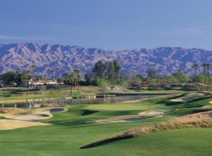 a golf course with a pond and mountains in the background at La Quinta Resort & Club in La Quinta