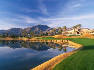 a golf course with palm trees and a lake at La Quinta Resort & Club in La Quinta