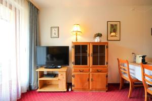 a living room with a television and a wooden cabinet at Chalet Miravalle 2 in Wengen
