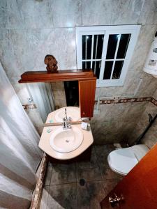 a bathroom with a sink and a dog on a shelf at Hostal White beach in Paraguchi