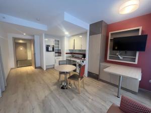a living room with a table and a kitchen at Appart One Chambéry in Chambéry