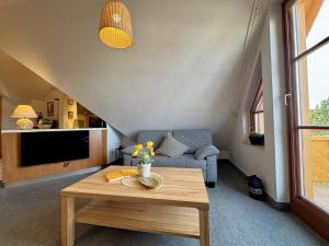 a living room with a table and a couch at Oewern Diek App 09 in Wustrow