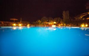 a large pool of blue water at night at Elpida Village in Istro