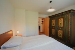 a bedroom with a bed and a wooden cabinet at Chalet Miravalle 3 in Wengen