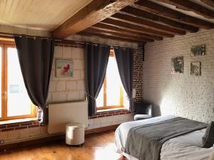 a bedroom with a bed and two windows at le chateau de PENIN in Penin