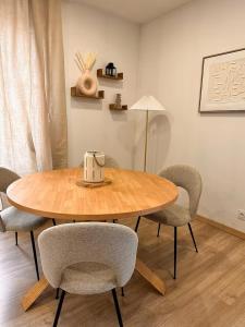 a dining room table with chairs and a lamp at Savane 2 bedrooms and private parking in Vesoul