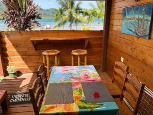a table and chairs sitting on a deck with a table and chairs at Hiva's Place climatisé terrasse vue sur mer -Huahine in HUH
