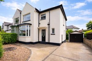 an exterior view of a white house with a driveway at Stylish Hot Tub House with free parking! in York