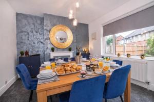 a dining room with a table with blue chairs at Stylish Hot Tub House with free parking! in York