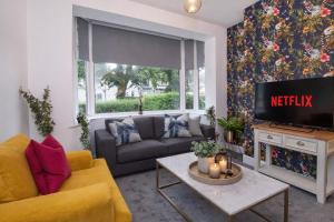 a living room with a couch and a tv at Stylish Hot Tub House with free parking! in York
