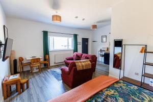 a living room with two chairs and a table at Modern Barn Conversion in Brackley