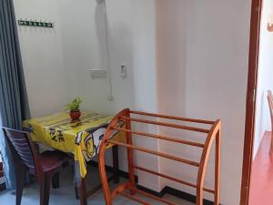 a table with a yellow table cloth and a plant on it at Sanda Villa Dodanduwa in Dodanduwa