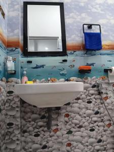 a bathroom with a sink and a fish mural at Sanda Villa Dodanduwa in Dodanduwa