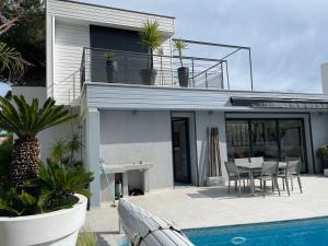 a house with a pool and a table and chairs at Villa Portal in La Grande Motte