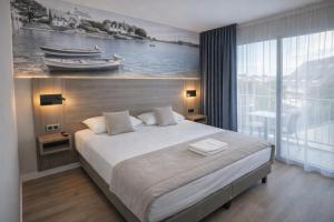a bedroom with a bed with a painting on the wall at Hotel Europa in Quiberon