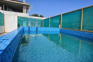 a large swimming pool with blue tiles on the side of a building at Elite Castle Stay in Kottakupam