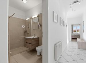 a white bathroom with a toilet and a sink at Residenz Waldhaus_05 in Zempin +1 photo