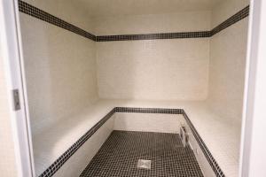 an empty bathroom with a shower with black and white tiles at Hotel Europa in Quiberon +27 photos