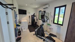 a room with a gym with exercise equipment in it at Stunning seaside villa with pool and jacuzzi in Boca Chica