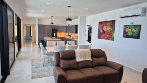 a living room with a couch and a kitchen at Stunning seaside villa with pool and jacuzzi in Boca Chica