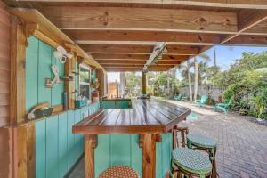an outdoor kitchen with a table and chairs at 2 Cottages Downtown Lake Worth - Private Pool in Lake Worth