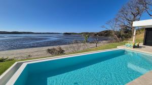 a swimming pool with a view of a river at Stunning seaside villa with pool and jacuzzi in Boca Chica