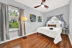 a bedroom with a bed and a ceiling fan at 2 Cottages Downtown Lake Worth - Private Pool in Lake Worth