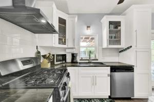 a kitchen with white cabinets and a stove top oven at 2 Cottages Downtown Lake Worth - Private Pool in Lake Worth