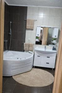 a bathroom with a tub and a sink and a mirror at Hidden Home in Zenica