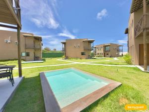 a swimming pool in the middle of a yard with houses at Beachfront Duplex B por Be My Guest in Aquiraz