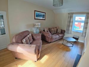 a living room with two couches and a table at Jessamine Cottage in Blairgowrie
