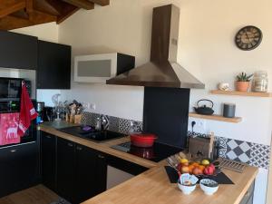 a kitchen with black cabinets and a counter with a bowl of fruit at Chalet Masana in Murat-le-Quaire