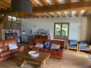 a living room with leather couches and a coffee table at Chalet Masana in Murat-le-Quaire