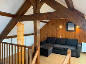 a living room with a couch in the attic at Chalet Masana in Murat-le-Quaire