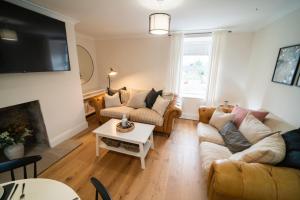 a living room with two couches and a tv at Foundry Farm Cottage in Hexham