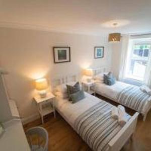 a living room with two beds and two lamps at Foundry Farm Cottage in Hexham