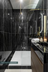 a black bathroom with a shower and a sink at PoeticStay - Neuilly sur Seine - Dulud in Neuilly-sur-Seine