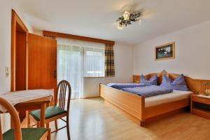 a bedroom with a bed and a dining table at Bergapartments Wötzinger in Berwang