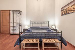 a bedroom with a bed with two wooden benches at Long John Apartment in Rome