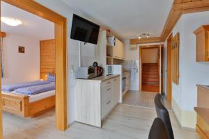 a kitchen with a bed and a tv on the wall at Bergapartments Wötzinger in Berwang +17 photos