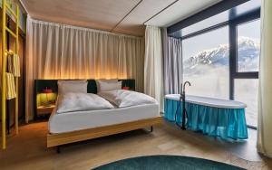 a bedroom with a bed with a tub and a window at Urban Nature Bad Gastein - Badeschloss in Bad Gastein +54 photos
