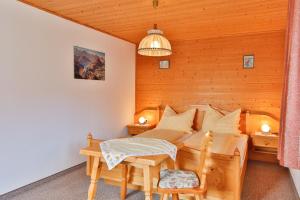 a bedroom with a bed and a table and chairs at Bergapartments Wötzinger in Berwang