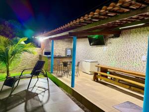 a patio with chairs and a bench and a table at Chácara Betel in Marechal Deodoro