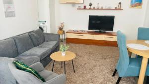a living room with a couch and a tv at Boulevard apartament in Sighetu Marmaţiei