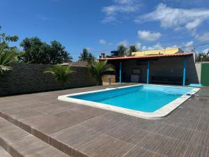 a swimming pool in front of a house at Chácara Betel in Marechal Deodoro
